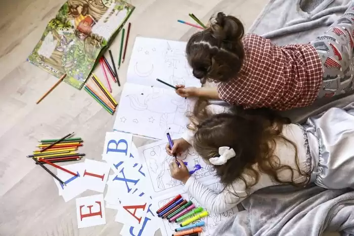 top-view-two-tiny-girls-which-are-drawing-coloring-book-laying-floor-blanket-1024x683.jpg