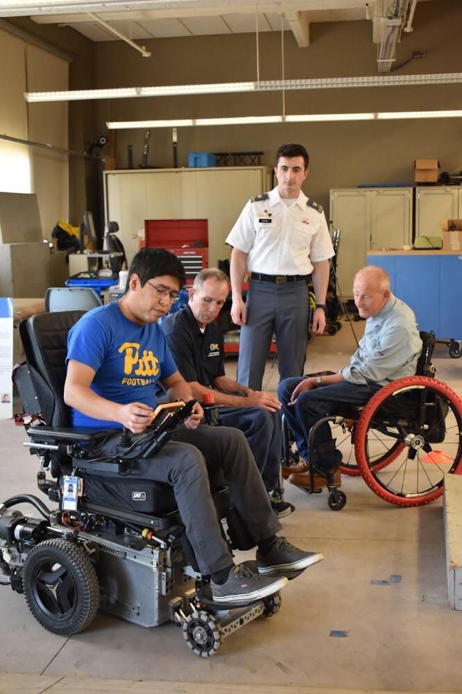 3-people-sitting-in-wheelchairs-and-1-man-standing.jpg